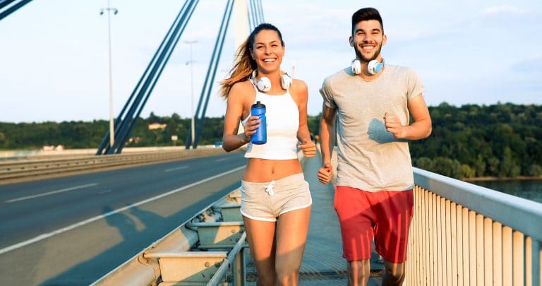 City running couple jogging outside. Runners training outdoors