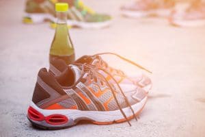 Running shoes and water bottles to health on floor.