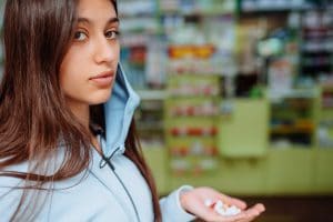 Coronavirus. Covid-19. Woman takes and shows pills, vitamins or pills in his hand. vitamins or pills. Health and treatment concept.