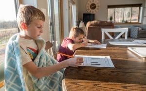 children being home schooled sitting at a table