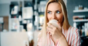 Middle aged blond woman putting cosmetics on