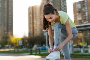 Young sporty beautiful woman tying sports shoe