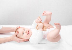 Baby laying on back while chiropractor is holding his head